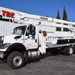 A white bucket truck parked outside a building